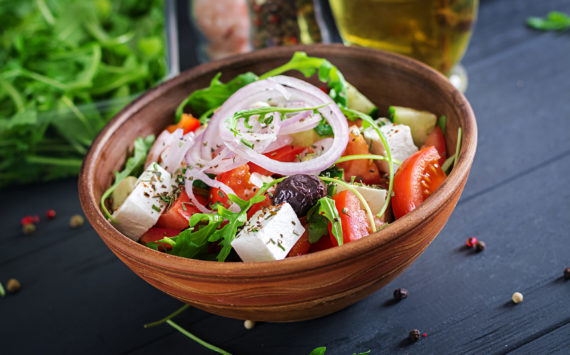 Greek salad with fresh tomato, cucumber, red onion, basil, feta cheese, black olives and Italian herbs